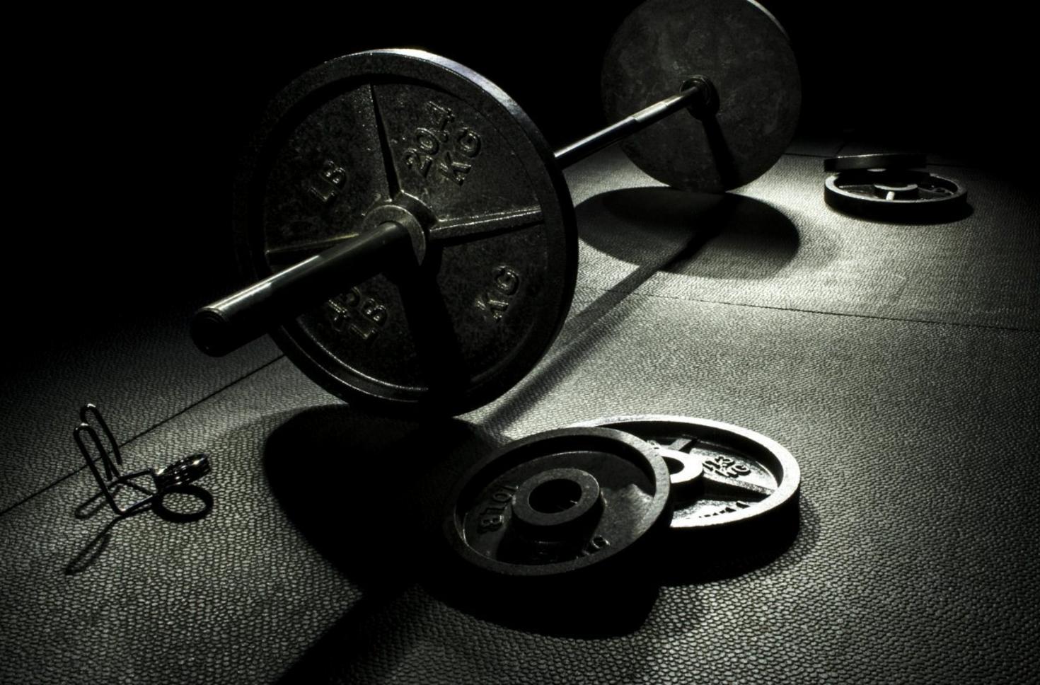 Barbell and weight plates on a gym floor